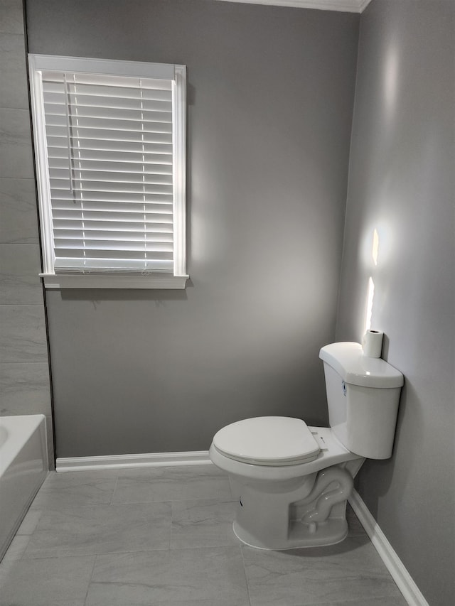 bathroom featuring a washtub and toilet