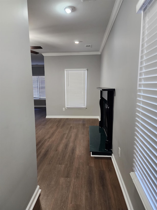 hallway with ornamental molding and dark wood-type flooring