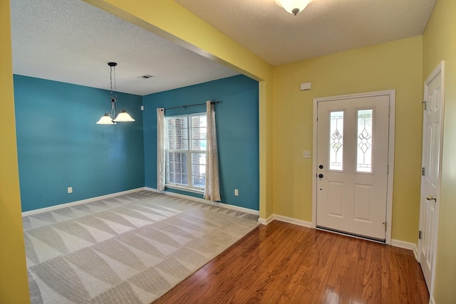 entrance foyer with hardwood / wood-style floors and a textured ceiling