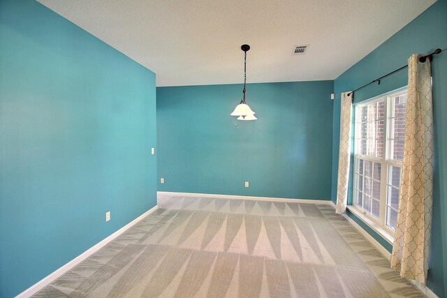 carpeted spare room with a textured ceiling