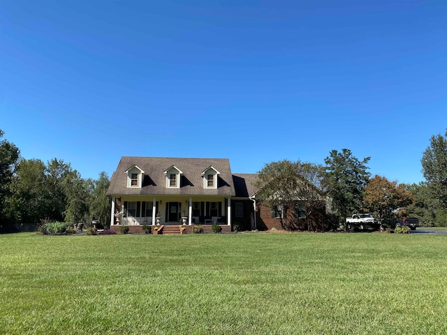 cape cod home with covered porch and a front lawn