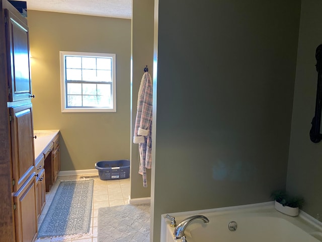 bathroom with vanity, a textured ceiling, tile patterned flooring, and a bathing tub