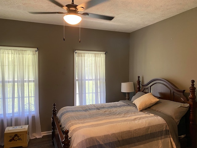 bedroom featuring a textured ceiling, dark wood-type flooring, and ceiling fan