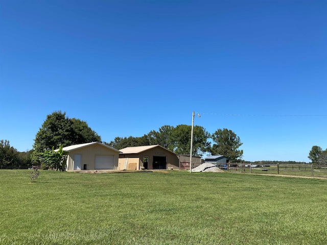 view of yard with a rural view and a garage