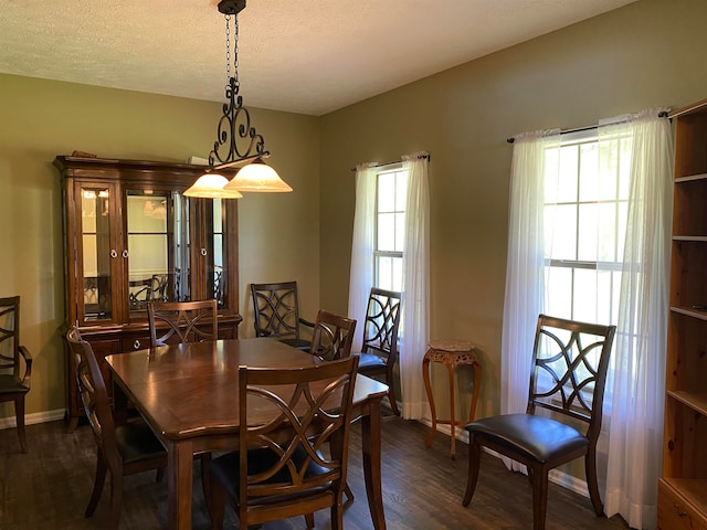 dining area with a textured ceiling and dark hardwood / wood-style flooring