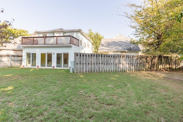 back of property featuring a balcony and a yard