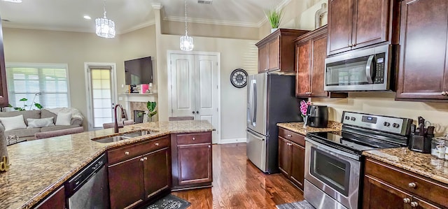 kitchen featuring sink, decorative light fixtures, dark wood-type flooring, stainless steel appliances, and light stone countertops