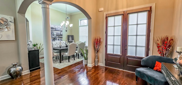 doorway to outside featuring ornamental molding, french doors, dark hardwood / wood-style floors, decorative columns, and a notable chandelier