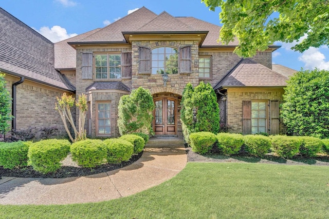 view of front of home featuring french doors and a front lawn