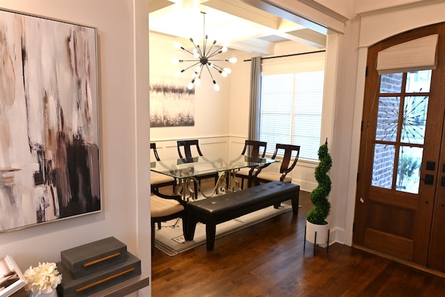 dining space with coffered ceiling, a wealth of natural light, dark wood-type flooring, and an inviting chandelier