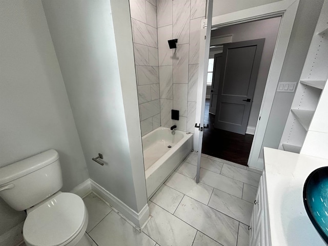 full bathroom featuring tile patterned flooring, tiled shower / bath combo, vanity, and toilet