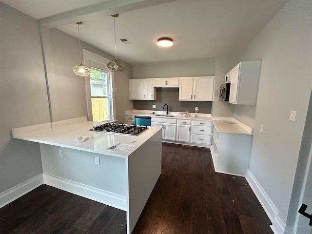 kitchen with dark hardwood / wood-style flooring, stainless steel appliances, kitchen peninsula, hanging light fixtures, and white cabinets