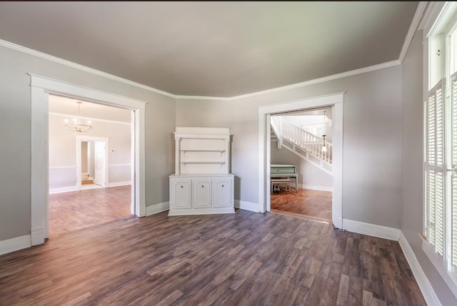 unfurnished living room with a notable chandelier, a healthy amount of sunlight, crown molding, and dark hardwood / wood-style flooring