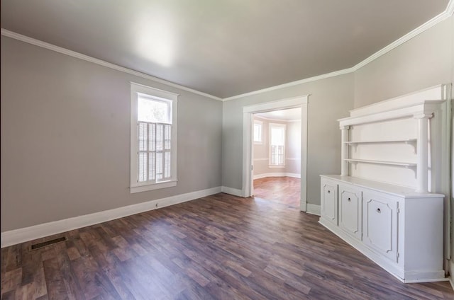 empty room featuring crown molding and dark hardwood / wood-style flooring