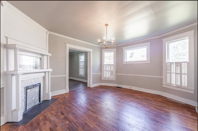 unfurnished living room featuring a brick fireplace, a chandelier, and dark hardwood / wood-style flooring