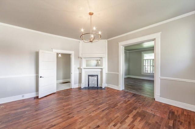 unfurnished living room with an inviting chandelier, a brick fireplace, ornamental molding, and dark hardwood / wood-style flooring