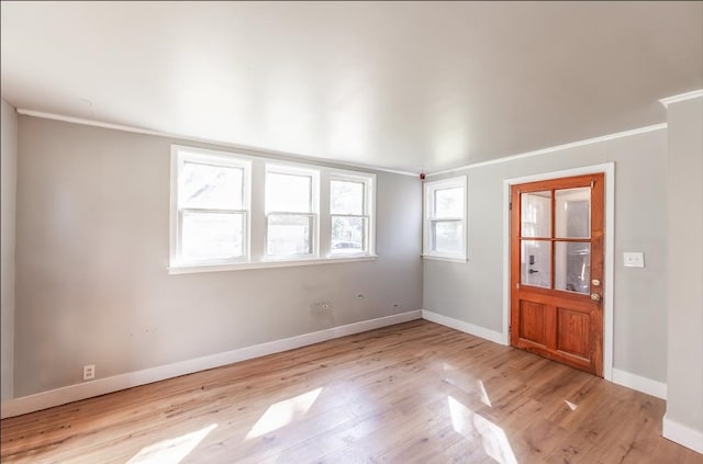 empty room with ornamental molding and light hardwood / wood-style flooring