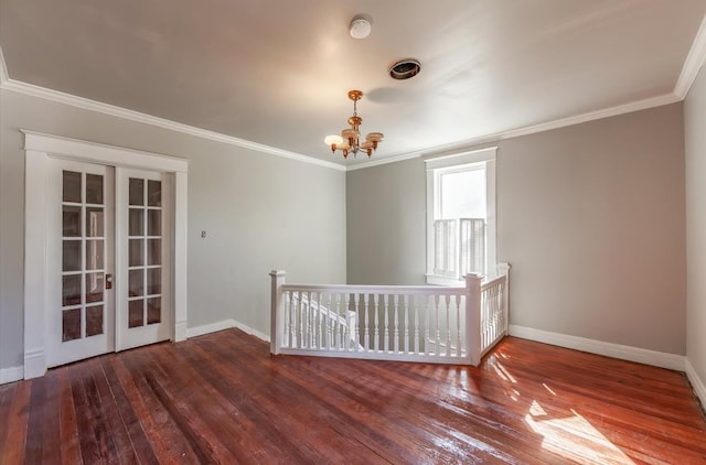 spare room featuring crown molding, an inviting chandelier, french doors, and dark hardwood / wood-style floors