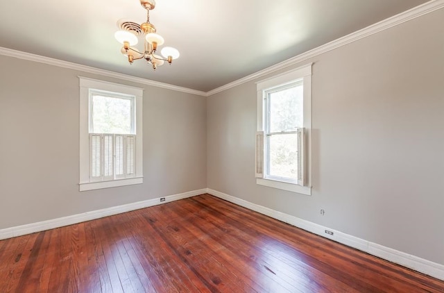 empty room with a notable chandelier, crown molding, and dark wood-type flooring