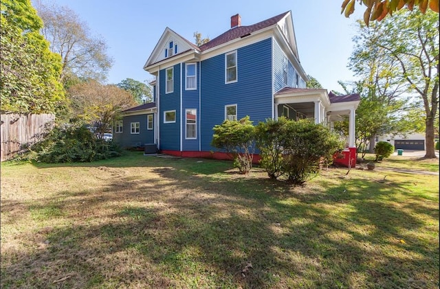 back of house featuring a lawn and central AC unit