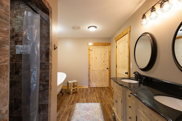 bathroom featuring wood-type flooring, shower with separate bathtub, and vanity