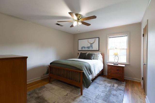 bedroom with crown molding, hardwood / wood-style floors, and ceiling fan