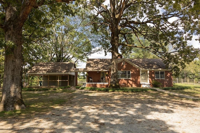 single story home featuring a sunroom