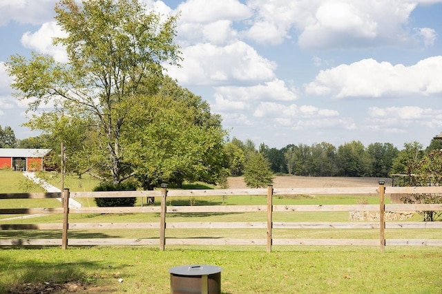 view of gate with a rural view and a lawn