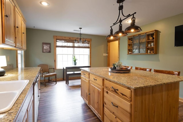 kitchen with a kitchen island, decorative light fixtures, sink, dark hardwood / wood-style floors, and stainless steel dishwasher