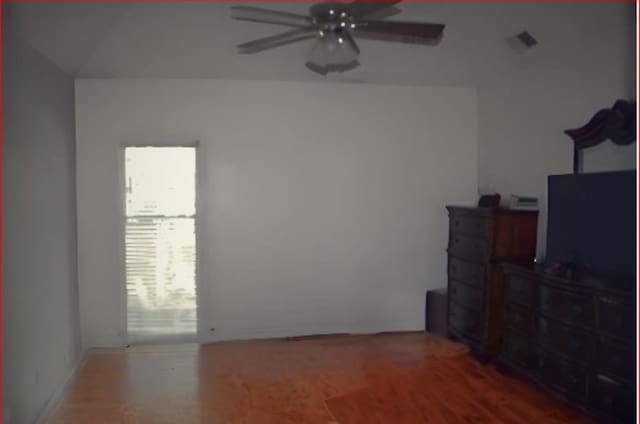 bedroom with hardwood / wood-style floors, ceiling fan, and vaulted ceiling