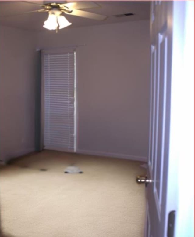 unfurnished room with carpet flooring and ceiling fan