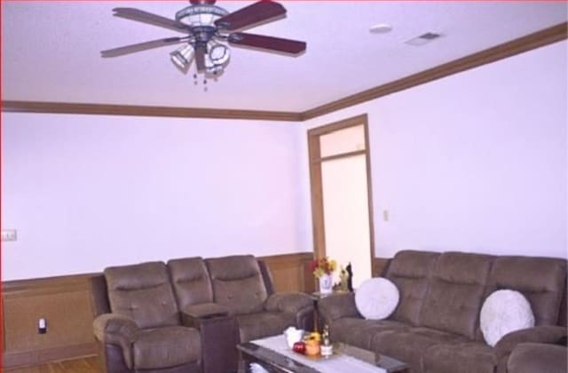 living room featuring ceiling fan and crown molding