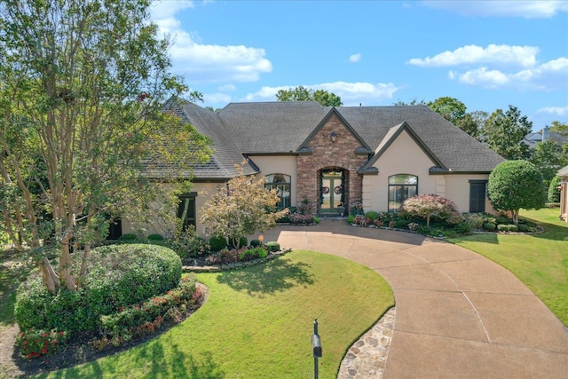 french country home featuring a front lawn