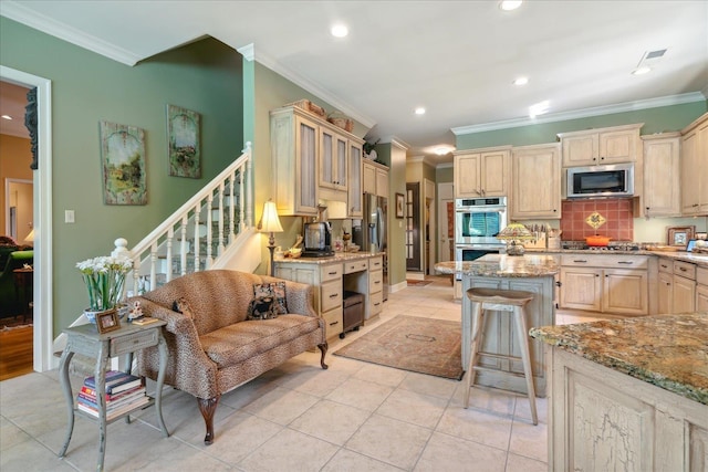 kitchen with ornamental molding, light stone countertops, a center island, and stainless steel appliances