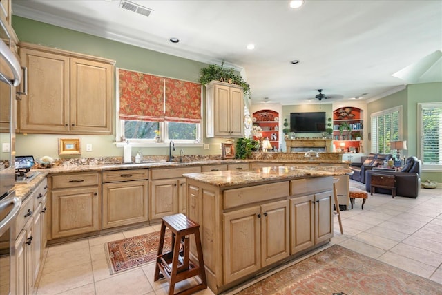 kitchen featuring ornamental molding, light brown cabinetry, and ceiling fan