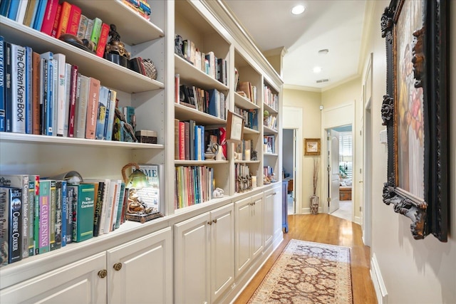 hallway featuring crown molding and light hardwood / wood-style floors