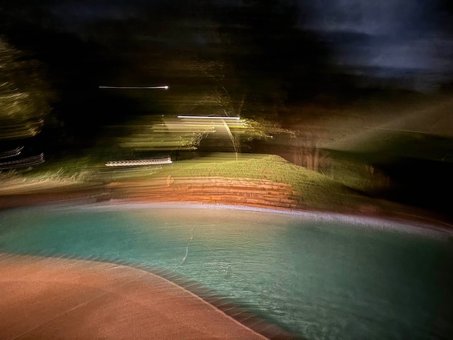 view of pool at twilight