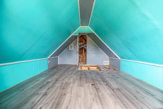 additional living space featuring lofted ceiling and hardwood / wood-style floors