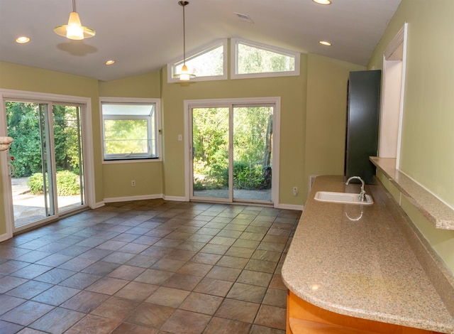 doorway to outside with vaulted ceiling, sink, and a wealth of natural light