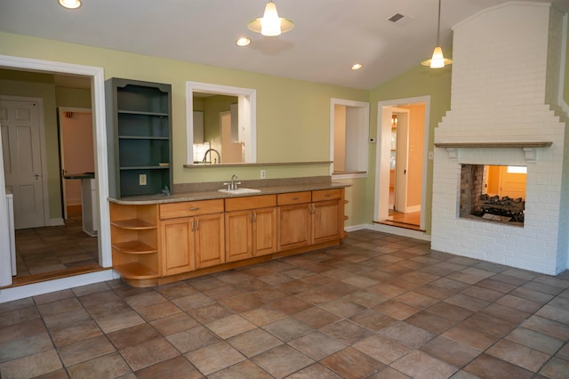 kitchen featuring lofted ceiling, sink, a fireplace, built in features, and decorative light fixtures