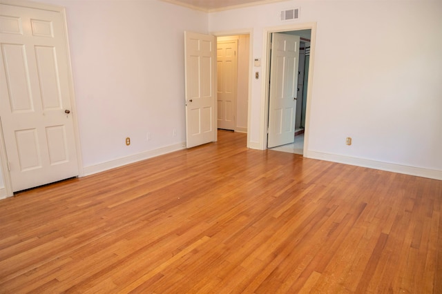 unfurnished bedroom with light hardwood / wood-style floors and crown molding