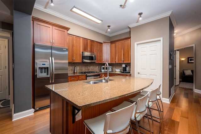 21 Mina Ave Unit 207, Memphis, TN 38103 - kitchen featuring stainless steel appliances, light wood-style flooring, tasteful backsplash, a kitchen bar, and ornamental molding