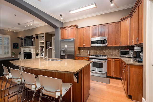 21 Mina Ave Unit 207, Memphis, TN 38103 - kitchen with appliances with stainless steel finishes, a sink, crown molding, brown cabinets, and rail lighting