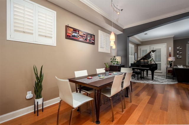 21 Mina Ave Unit 207, Memphis, TN 38103 - dining area featuring wood finished floors, ornamental molding, baseboards, and rail lighting