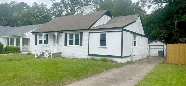 view of front of house featuring a garage, an outdoor structure, and a front lawn