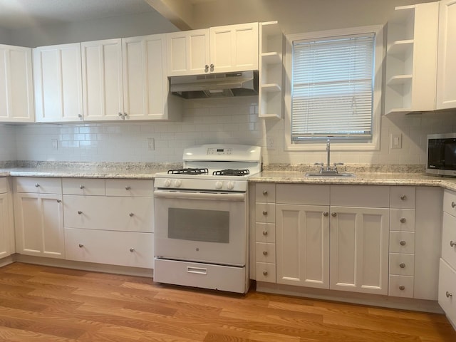 kitchen featuring sink, white cabinetry, light hardwood / wood-style flooring, white gas stove, and backsplash