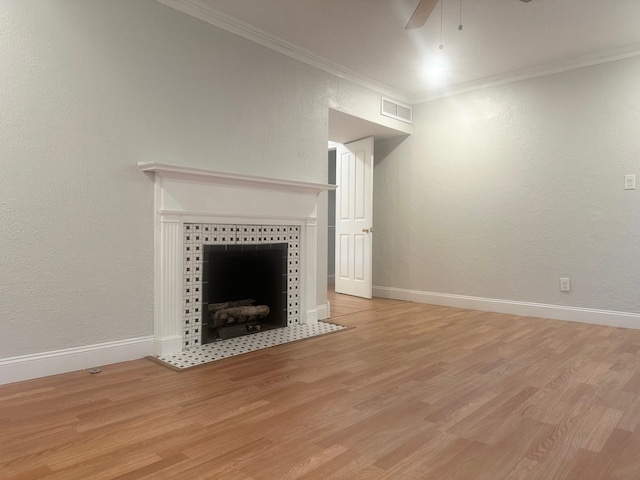 unfurnished living room featuring a fireplace, crown molding, light hardwood / wood-style flooring, and ceiling fan