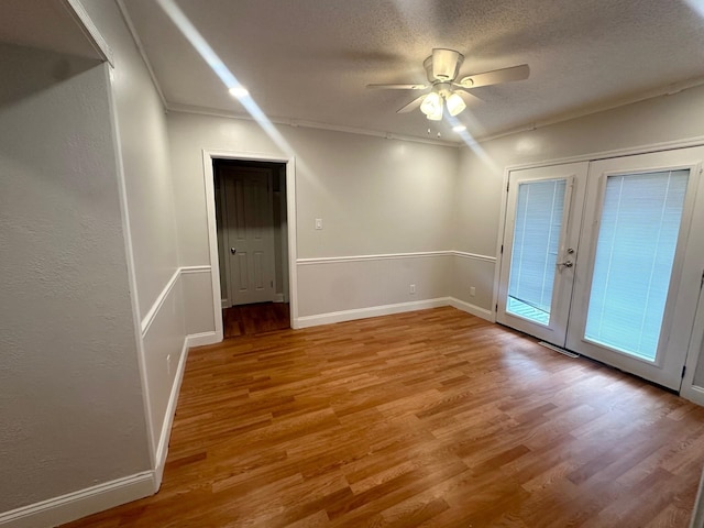 interior space with wood-type flooring, ornamental molding, a textured ceiling, and ceiling fan