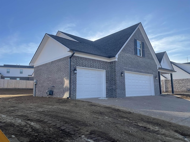 view of property exterior featuring an attached garage, brick siding, a shingled roof, fence, and driveway