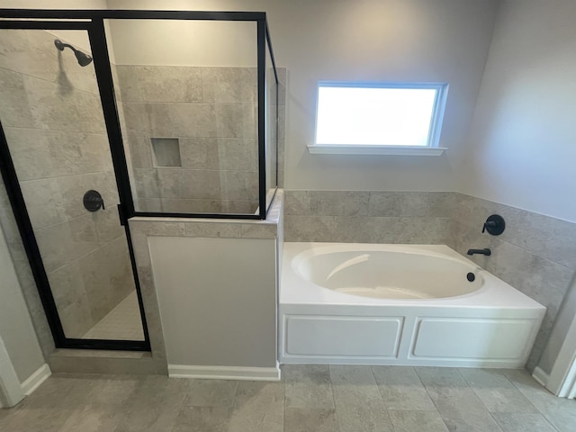 bathroom with a stall shower and a garden tub